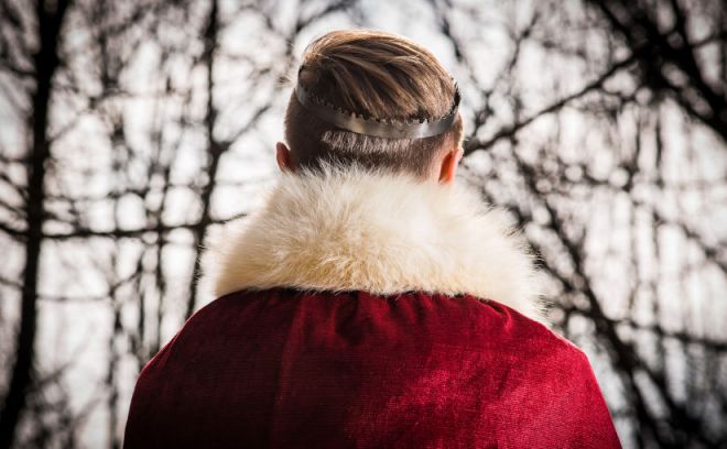 Usando corona y manto rojo