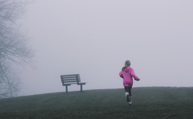 Chica corriendo hacia niebla